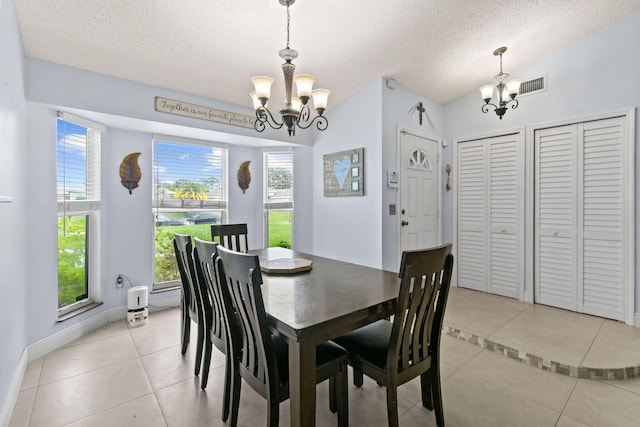 tiled dining space featuring vaulted ceiling, a chandelier, and a textured ceiling