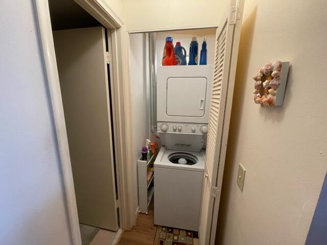 washroom featuring stacked washer and clothes dryer