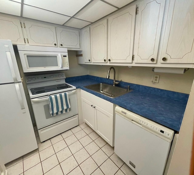 kitchen with sink, white cabinets, a paneled ceiling, white appliances, and light tile patterned floors