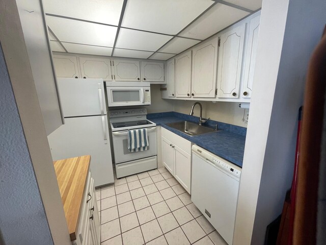 kitchen with white cabinets, white appliances, a paneled ceiling, and sink