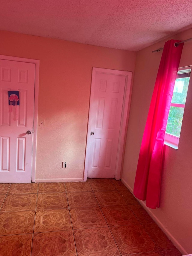 unfurnished bedroom featuring tile patterned floors and a textured ceiling