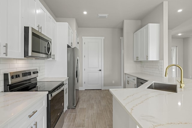 kitchen featuring decorative backsplash, appliances with stainless steel finishes, sink, and light stone countertops