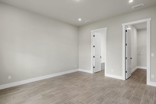 unfurnished bedroom featuring a walk in closet, light hardwood / wood-style floors, and a closet