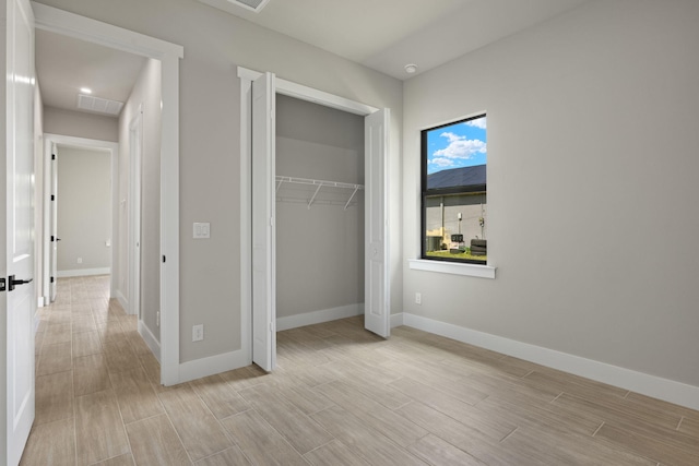 unfurnished bedroom featuring light hardwood / wood-style flooring and a closet