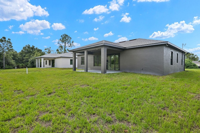 back of house with a lawn and a patio