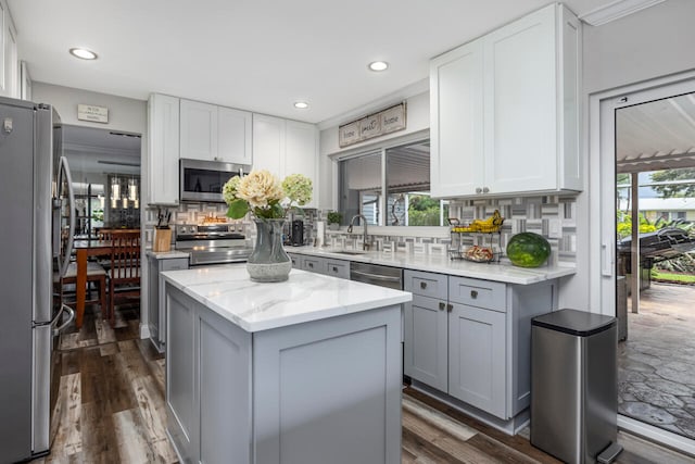 kitchen with dark hardwood / wood-style floors, stainless steel appliances, a wealth of natural light, and decorative backsplash