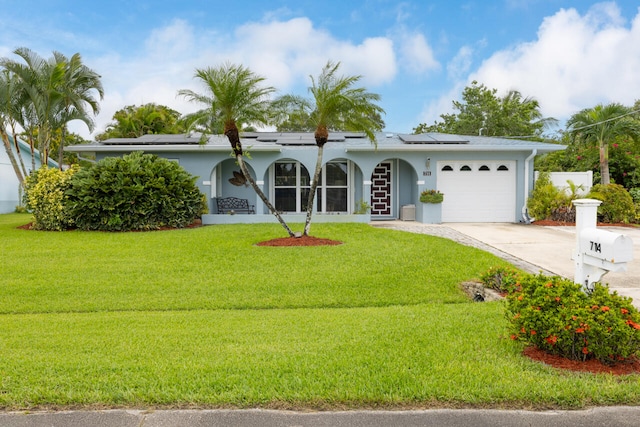 single story home with a front lawn, solar panels, and a garage