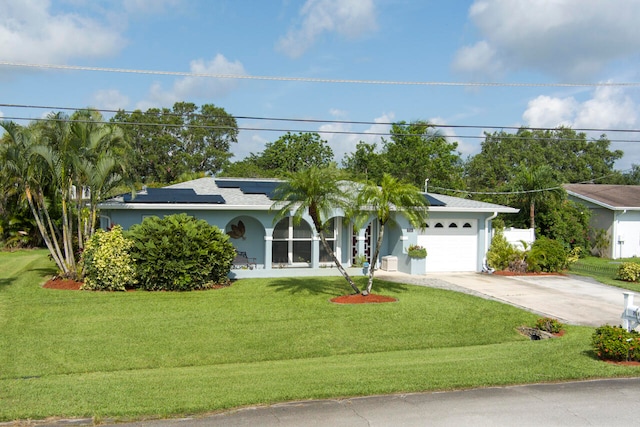 ranch-style house with a garage, a front lawn, and solar panels