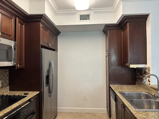 kitchen featuring sink, stainless steel appliances, a textured ceiling, light tile patterned flooring, and decorative backsplash