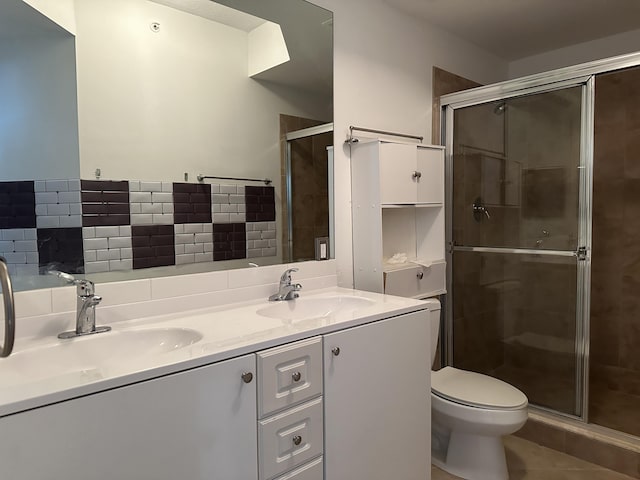 bathroom featuring vanity, toilet, and a shower with shower door