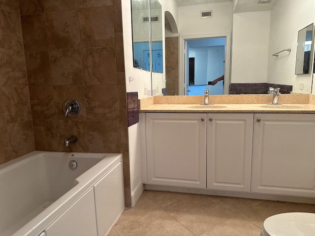 full bathroom featuring tiled shower / bath combo, vanity, tile patterned floors, and toilet