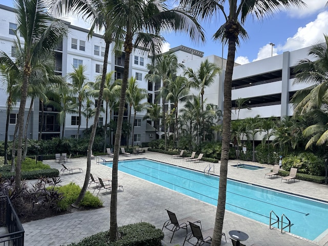 view of pool featuring a community hot tub and a patio area