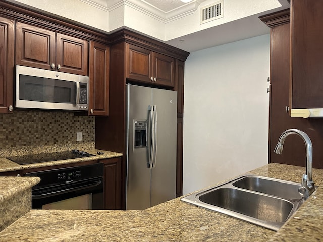 kitchen with sink, decorative backsplash, dark brown cabinetry, and black appliances