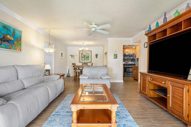 living room featuring ceiling fan with notable chandelier, crown molding, and a textured ceiling