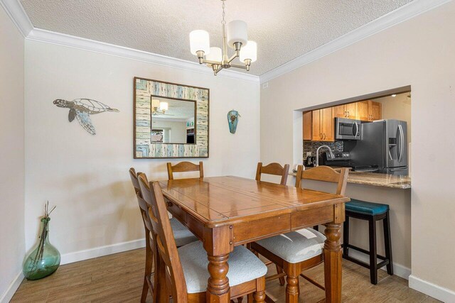 dining space featuring ornamental molding and a textured ceiling