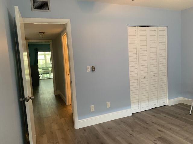 interior space with a closet, visible vents, baseboards, and wood finished floors