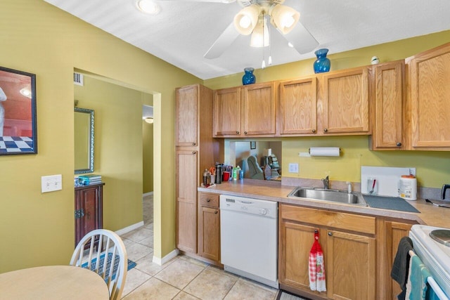 kitchen with light tile patterned floors, white appliances, a sink, a ceiling fan, and light countertops