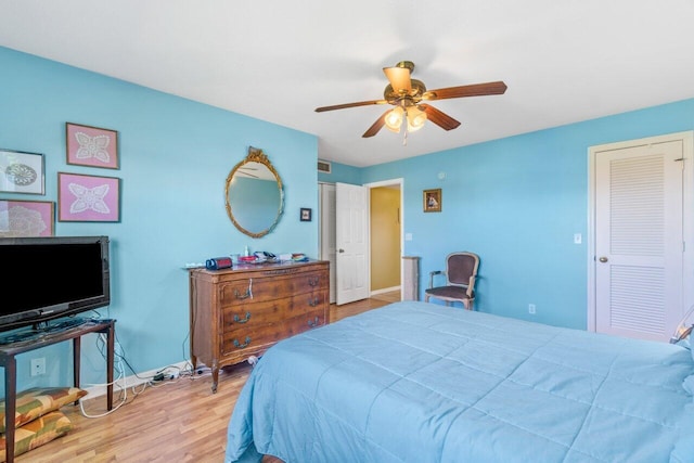 bedroom featuring visible vents, light wood finished floors, a ceiling fan, and baseboards