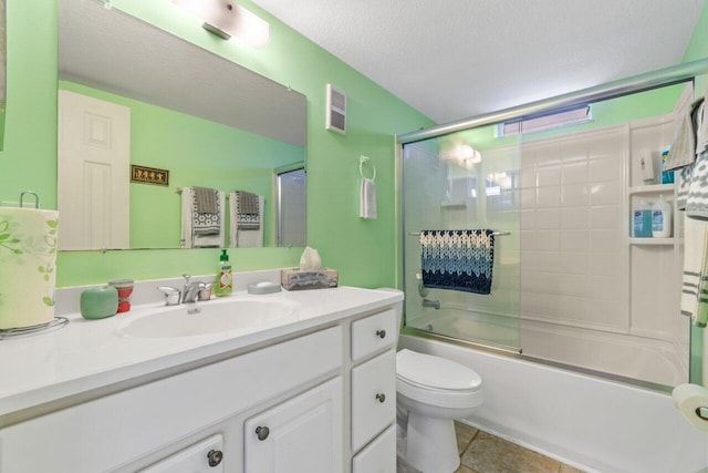 full bath with a textured ceiling, toilet, visible vents, vanity, and combined bath / shower with glass door