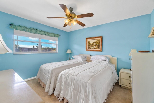 bedroom with light carpet, baseboards, and a ceiling fan