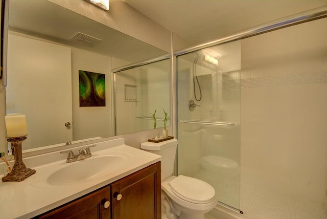 bathroom with vanity, toilet, and an enclosed shower