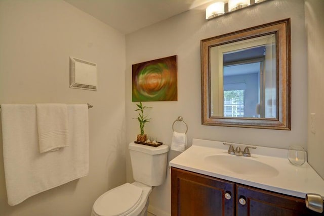 half bathroom with vanity and toilet