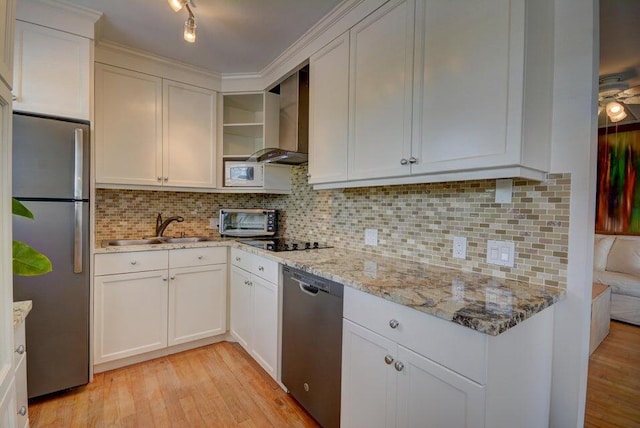 kitchen with sink, wall chimney exhaust hood, stainless steel appliances, light hardwood / wood-style flooring, and white cabinets