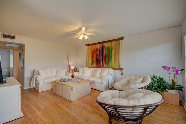 living room featuring visible vents, a ceiling fan, and light wood-style floors