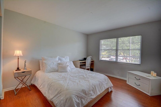 bedroom featuring wood finished floors and baseboards