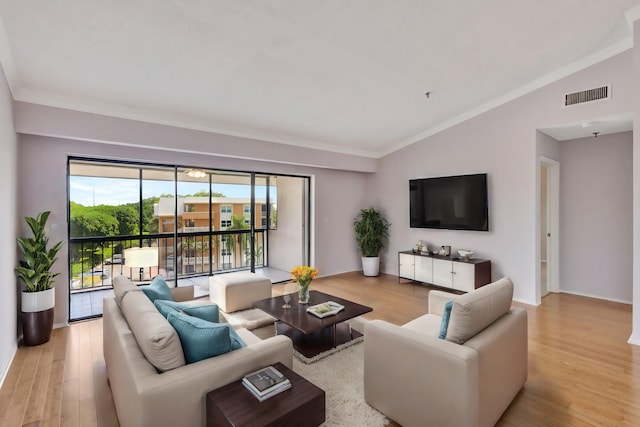 living room with vaulted ceiling, light hardwood / wood-style flooring, and crown molding