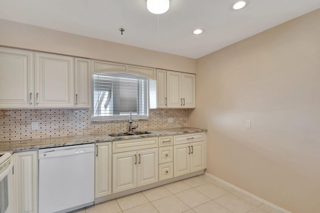 kitchen with backsplash, dishwasher, sink, light stone counters, and light tile patterned flooring