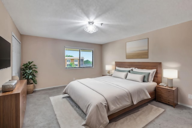 bedroom featuring light carpet and baseboards