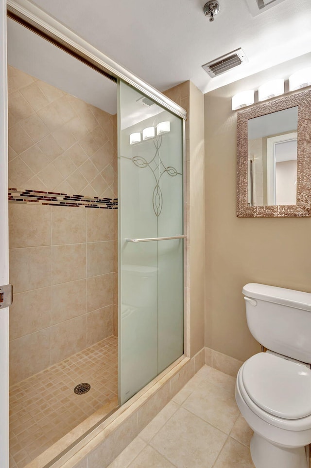 bathroom featuring toilet, walk in shower, and tile patterned flooring