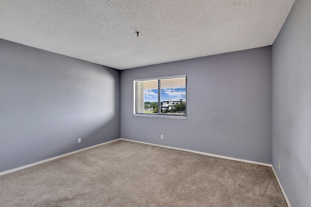 carpeted spare room with a textured ceiling