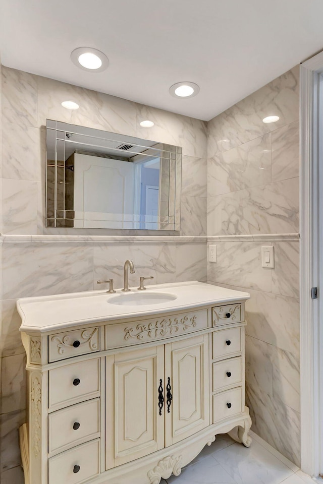 bathroom featuring tile patterned flooring, tile walls, vanity, and backsplash