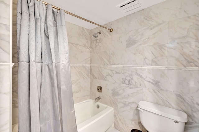 bathroom with shower / bath combo, toilet, and tile walls