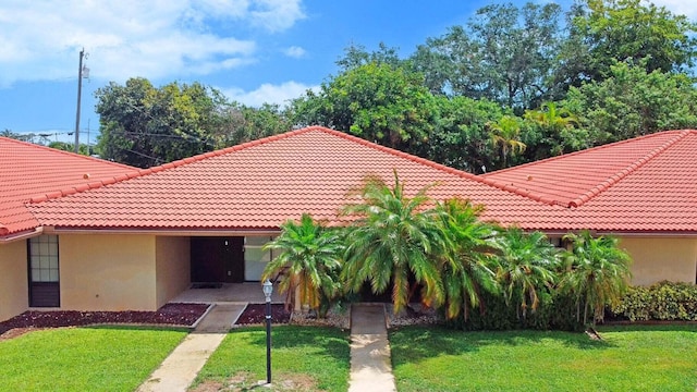 mediterranean / spanish-style home with a front yard