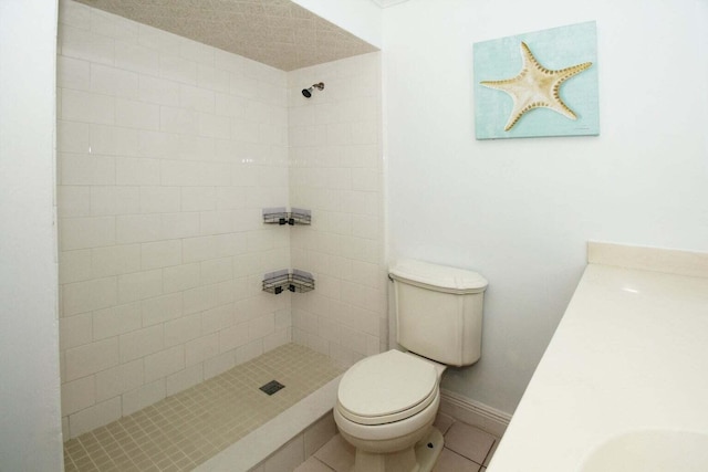 bathroom with tiled shower, tile patterned flooring, toilet, and a textured ceiling