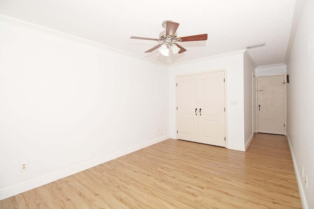 unfurnished bedroom featuring a closet, light hardwood / wood-style flooring, ornamental molding, and ceiling fan