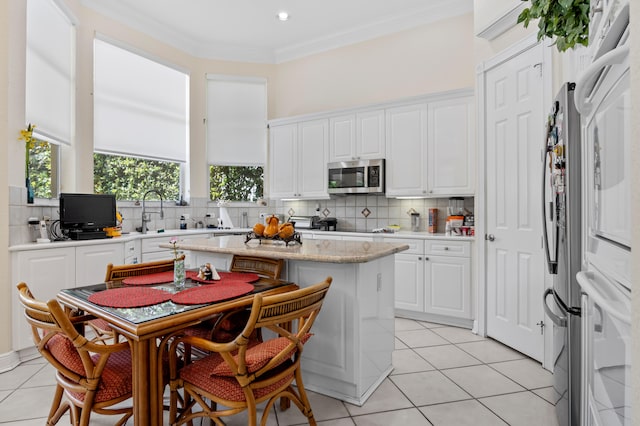 kitchen with crown molding, white cabinets, and decorative backsplash