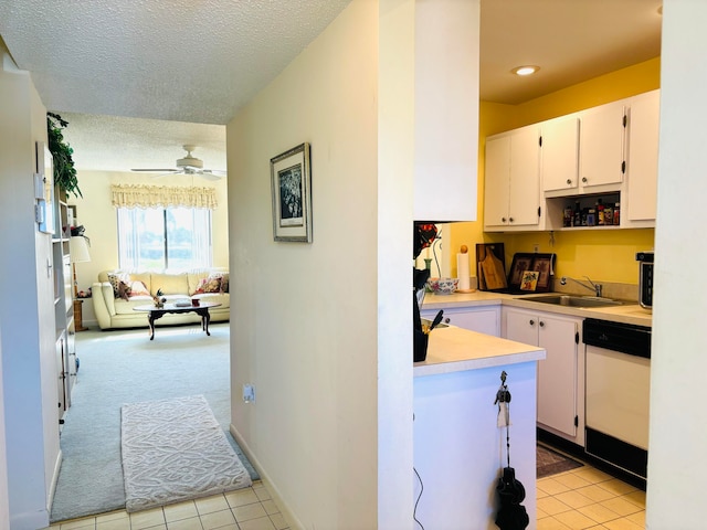 kitchen with white cabinets, sink, dishwasher, light carpet, and ceiling fan