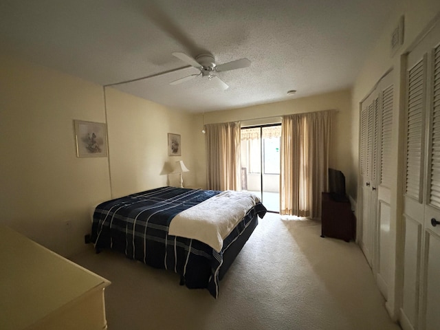 carpeted bedroom featuring a textured ceiling and ceiling fan