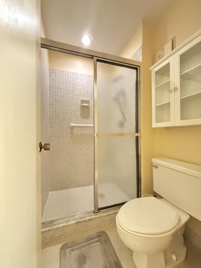 bathroom featuring walk in shower and toilet