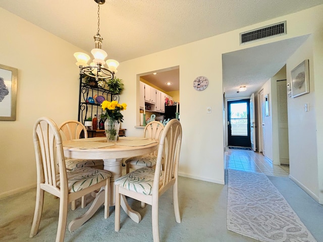 dining room featuring an inviting chandelier, a textured ceiling, and light colored carpet