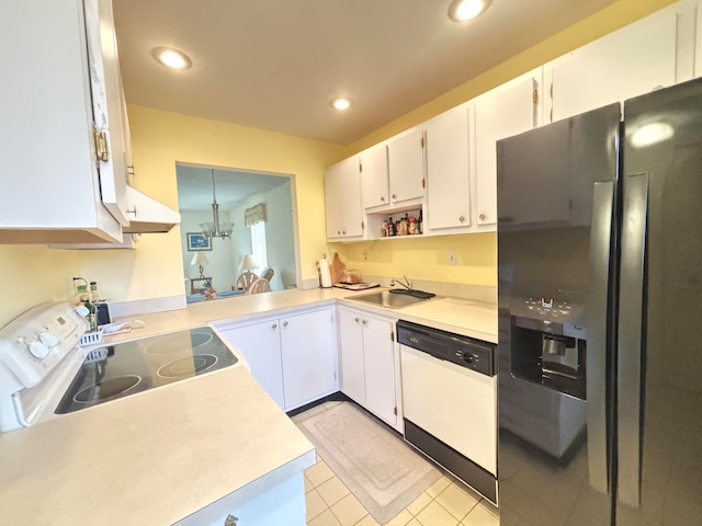 kitchen featuring light tile patterned flooring, white cabinetry, white dishwasher, stainless steel fridge, and sink