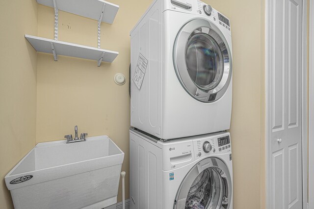 laundry room featuring stacked washer and clothes dryer and sink