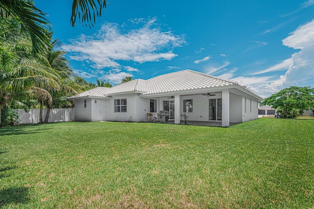 back of property featuring a yard, ceiling fan, and a patio area