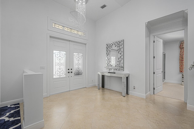 foyer entrance with french doors and an inviting chandelier