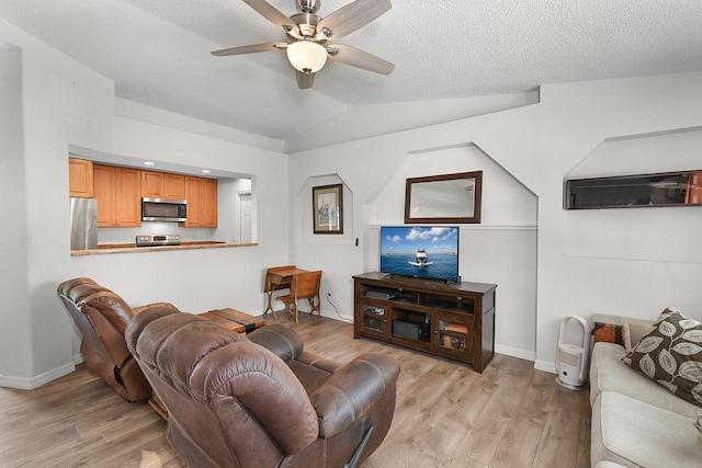 living room with light wood-type flooring, ceiling fan, lofted ceiling, and a textured ceiling