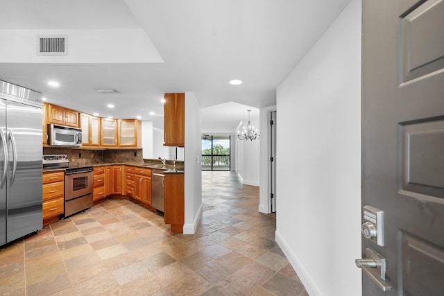 kitchen with backsplash, stainless steel appliances, sink, decorative light fixtures, and a chandelier